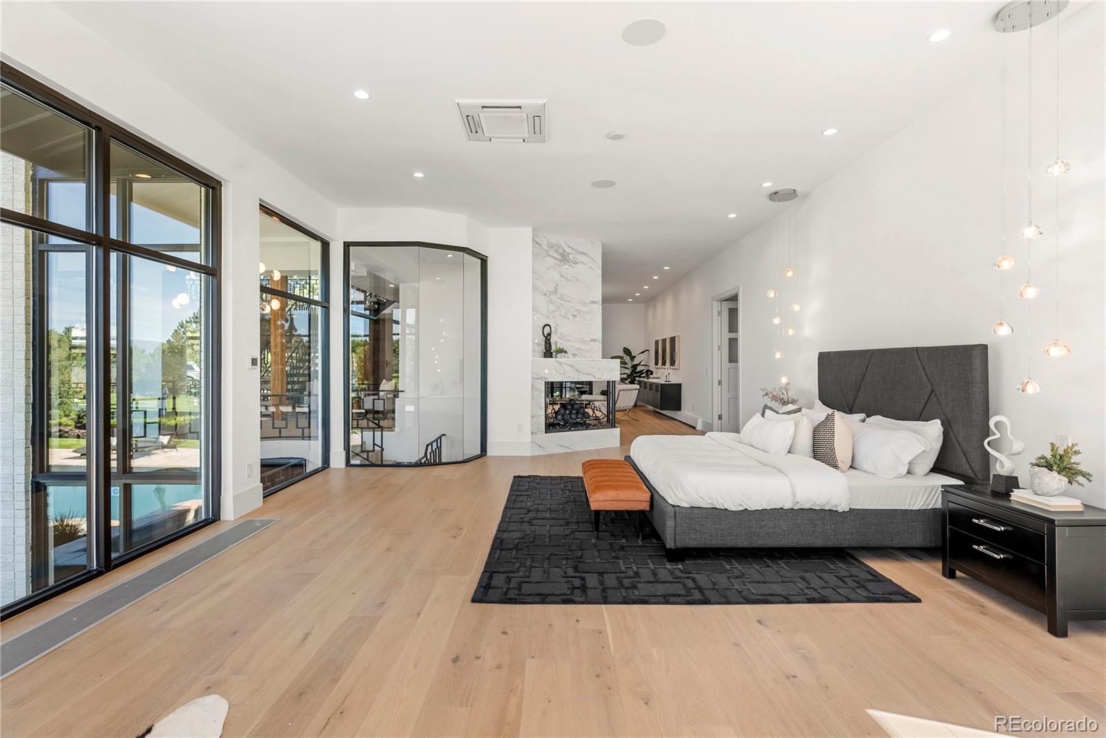 3962 South Chase Way Denver, CO 80235 - Photo 25 of 40 a large bedroom with a large bed a rug and a large window