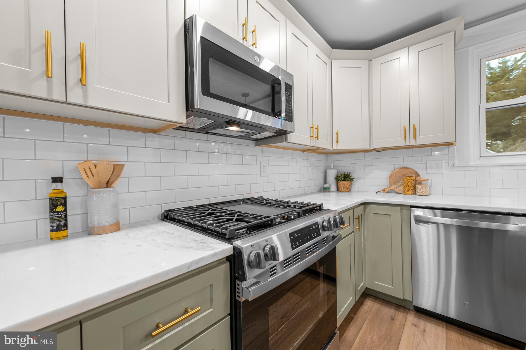 220 North Rolling Road Springfield, PA 19064 - Photo 4 of 41 a kitchen with stainless steel appliances granite countertop a sink a stove and microwave