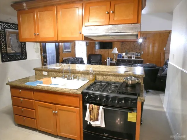 a kitchen with stainless steel appliances granite countertop a stove and a microwave oven