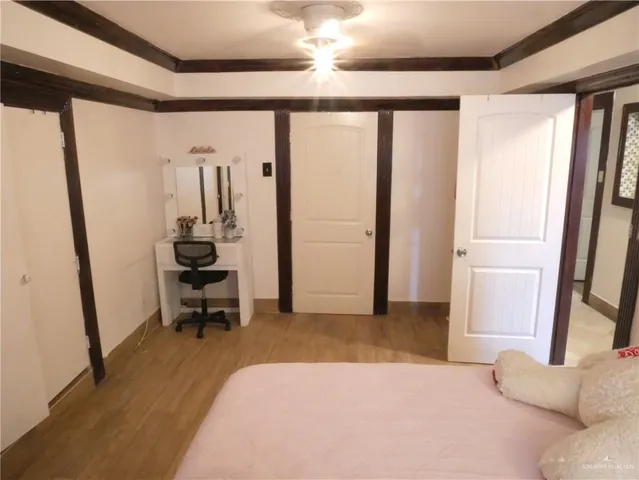 a bedroom with a bed and a flat tv screen on the dresser