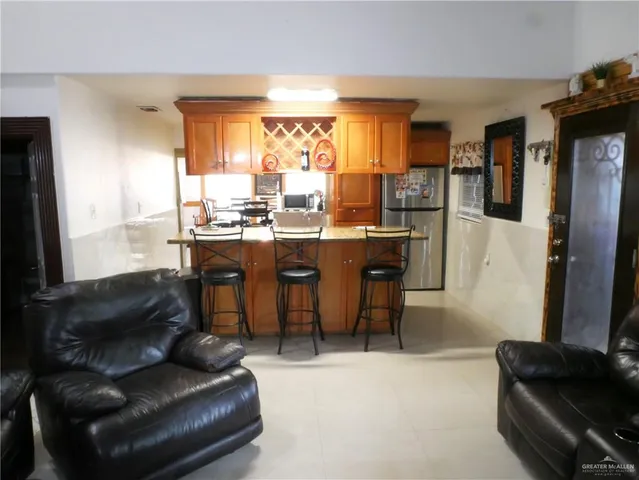 a room with stainless steel appliances kitchen island granite countertop furniture and a large window