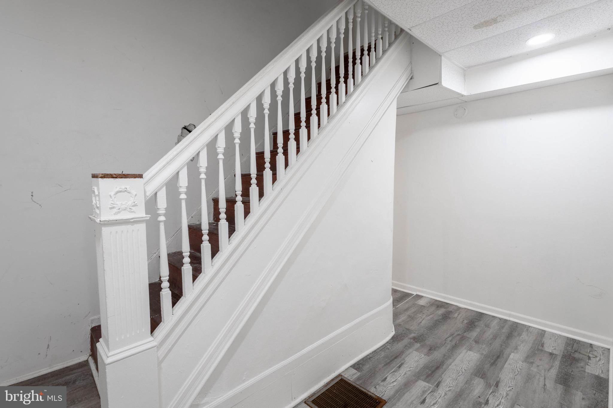 3207 Baker Street Baltimore, MD 21216 - Photo 4 of 14 a view of staircase with wooden floor and white walls