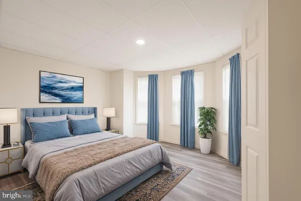 a bedroom with a large bed and a potted plant