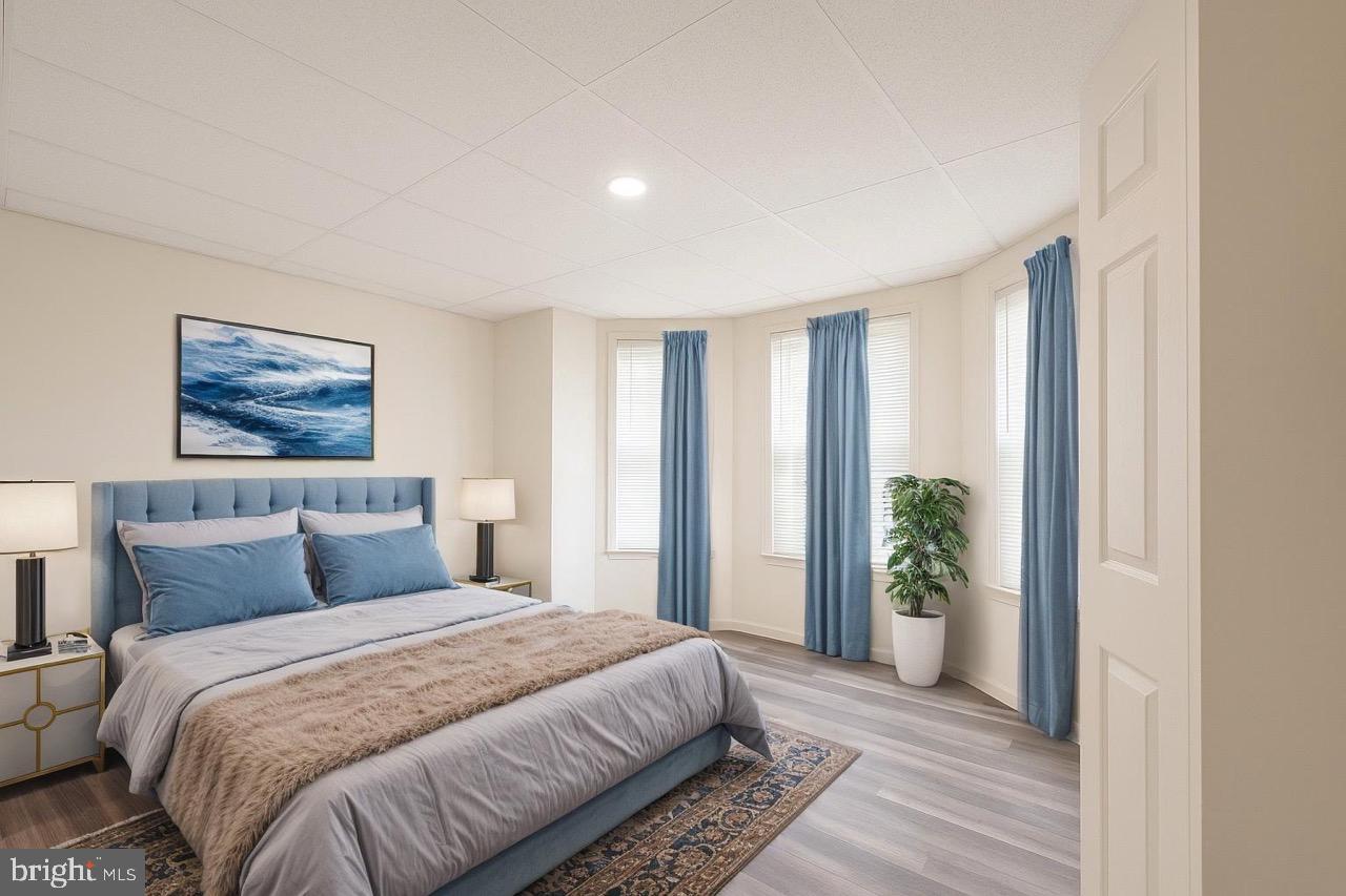 3207 Baker Street Baltimore, MD 21216 - Photo 8 of 14 a bedroom with a large bed and a potted plant