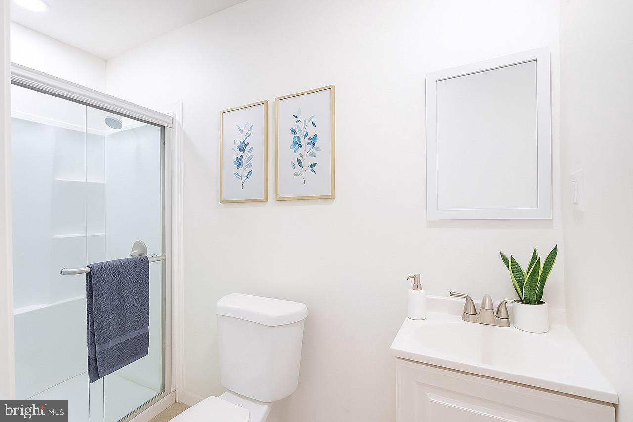 3207 Baker Street Baltimore, MD 21216 - Photo 9 of 14 a bathroom with a toilet a sink and mirror
