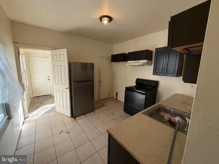 a kitchen with a refrigerator and a stove top oven