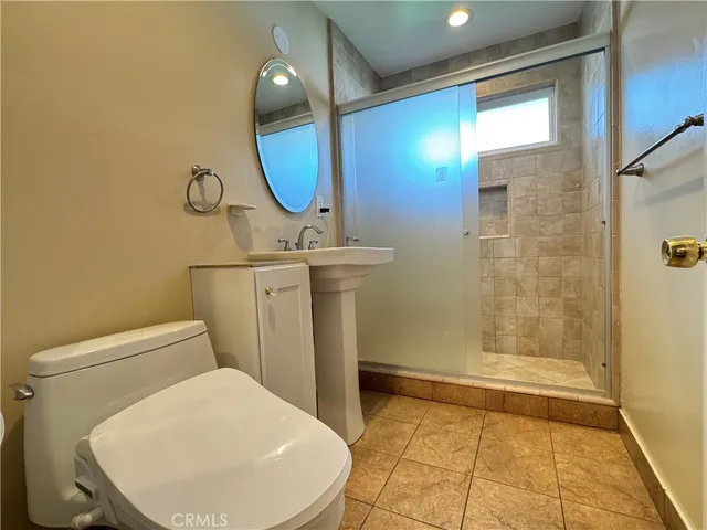 a bathroom with a toilet a sink and shower