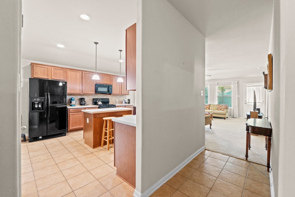 12008 Lansdowne Road Austin, TX 78754 - Photo 5 of 29 Functional kitchen with ample cabinet space opens into a comfortable living area.