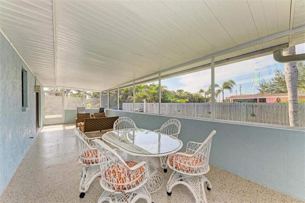 401 Shore Road Nokomis, FL 34275 - Photo 13 of 14 a view of a patio with table and chairs and floor to ceiling window with wooden floor