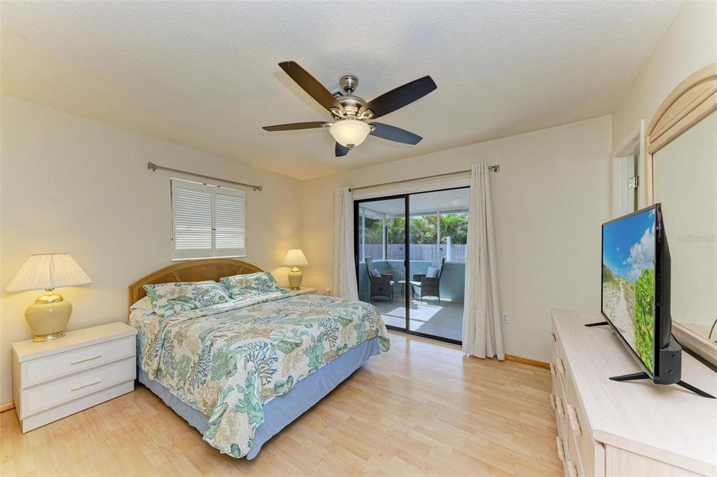 401 Shore Road Nokomis, FL 34275 - Photo 8 of 14 a bedroom with a bed and a flat tv screen on dresser