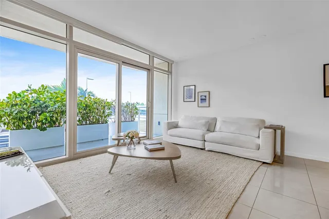 a living room with furniture and a dining table with wooden floor