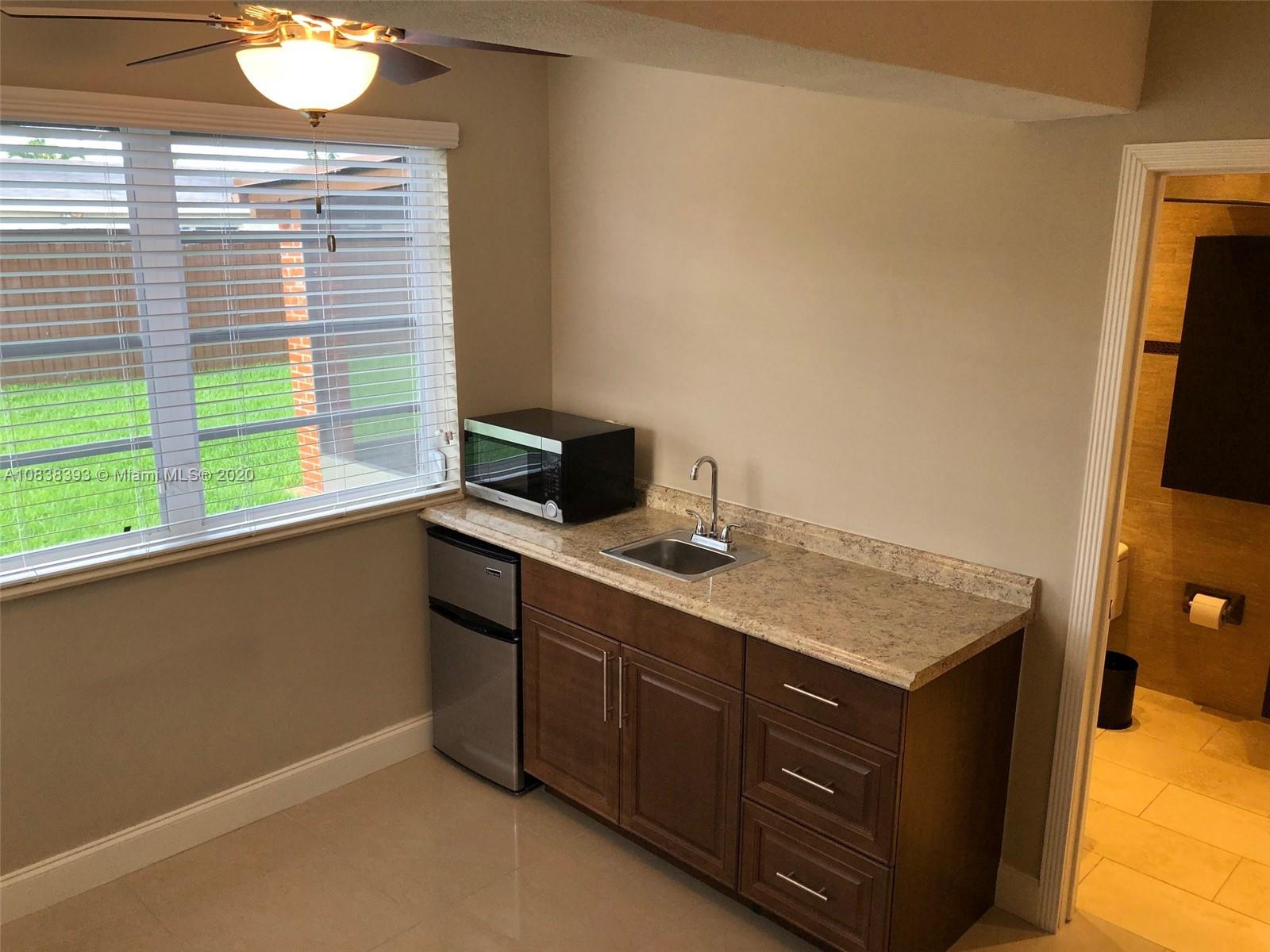 1220 West 62nd Street Hialeah, FL 33012 - Photo 12 of 53 a room with a sink cabinets and a flat screen tv