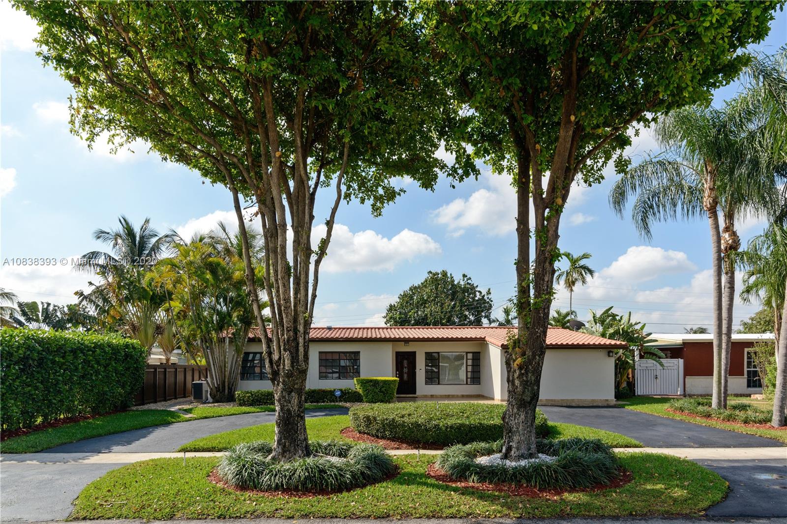 1220 West 62nd Street Hialeah, FL 33012 - Photo 19 of 53 a front view of a house with garden and trees
