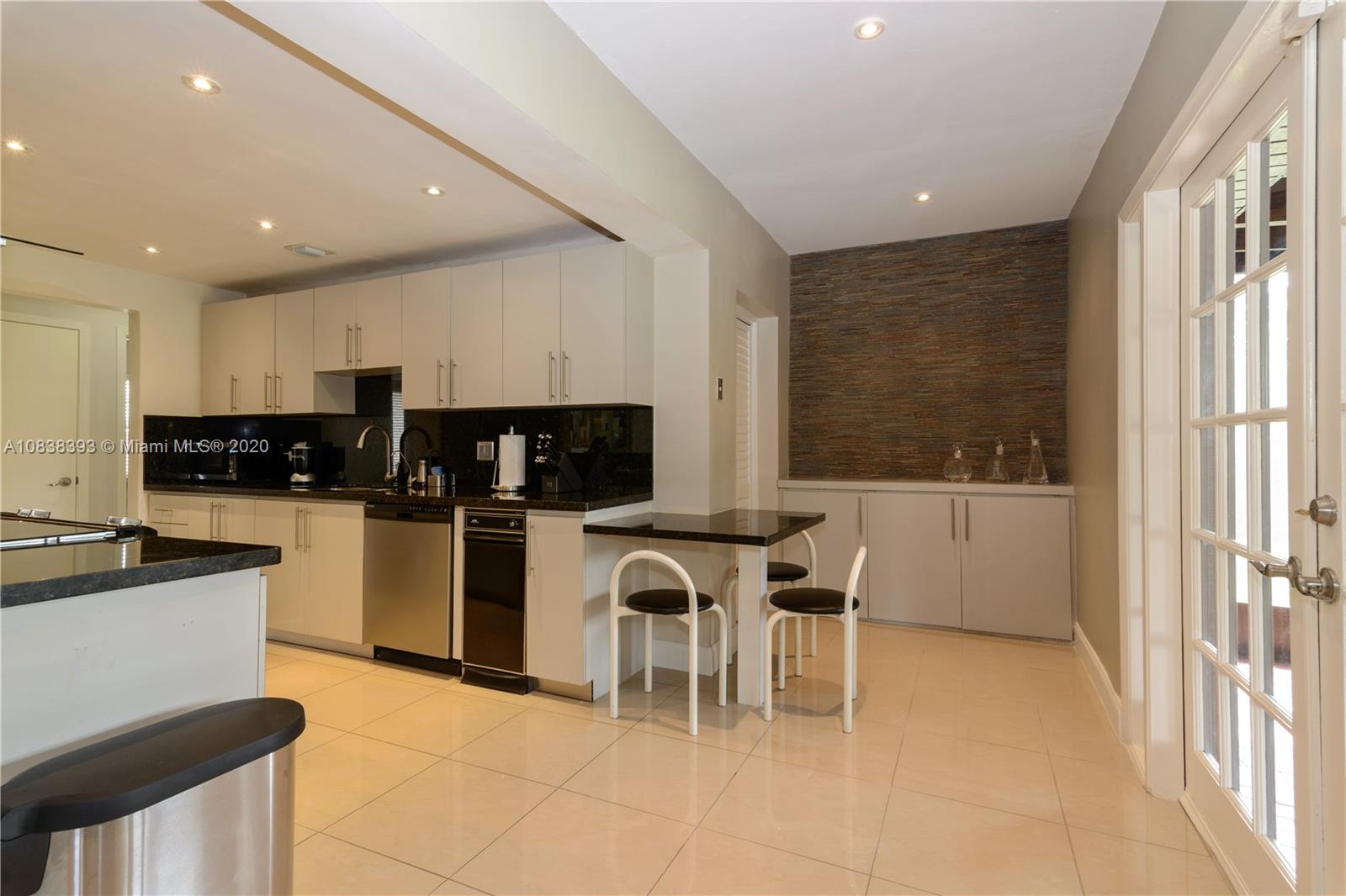 1220 West 62nd Street Hialeah, FL 33012 - Photo 30 of 53 a kitchen with stainless steel appliances granite countertop a stove top oven a sink a dining table and chairs