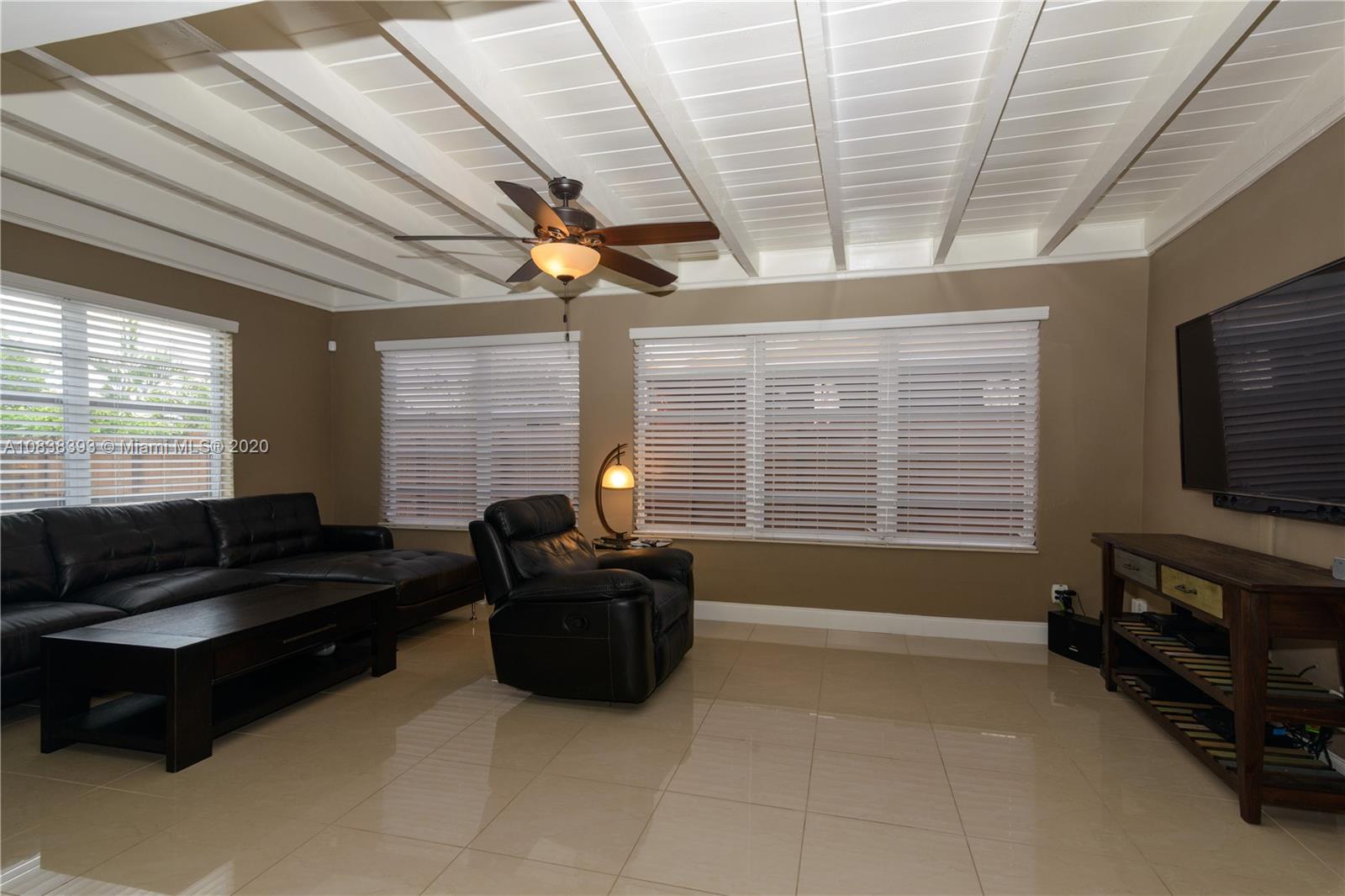 1220 West 62nd Street Hialeah, FL 33012 - Photo 32 of 53 a living room with furniture a flat screen tv and a large window
