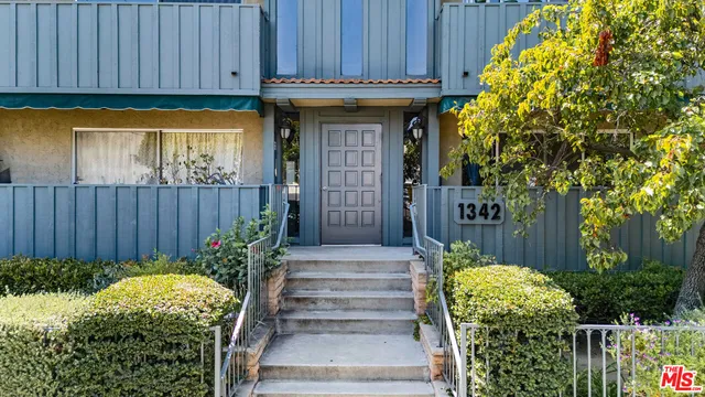 a front view of a house with plants
