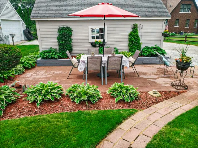 a view of a patio with table and chairs under an umbrella