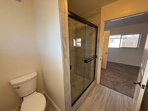 150 North Acacia Avenue Ripon, CA 95366 - Photo 19 of 54 a bathroom with a toilet and a shower