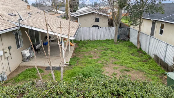 a view of a house with a backyard and a large tree