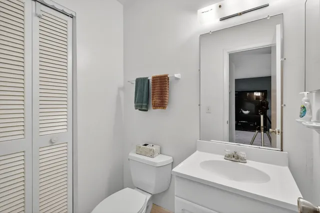 a bathroom with a toilet a sink and mirror