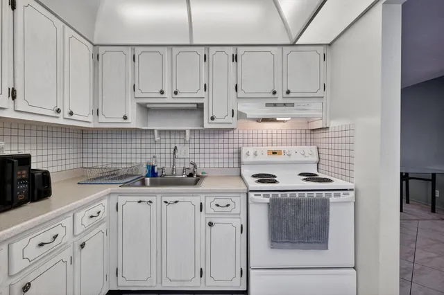 a kitchen with stainless steel appliances granite countertop a sink stove and cabinets
