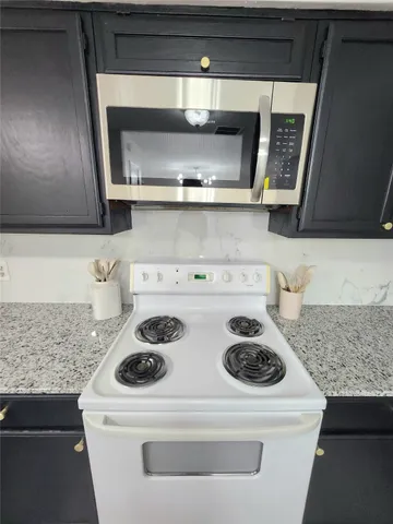 a white stove top oven sitting inside of a kitchen