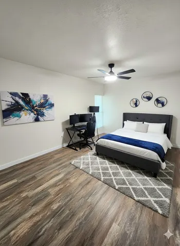 a bedroom with furniture and a wooden floor