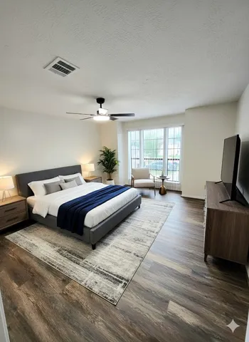 a bedroom with a bed and wooden floor