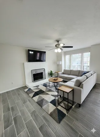 a living room with furniture a fireplace and a flat screen tv