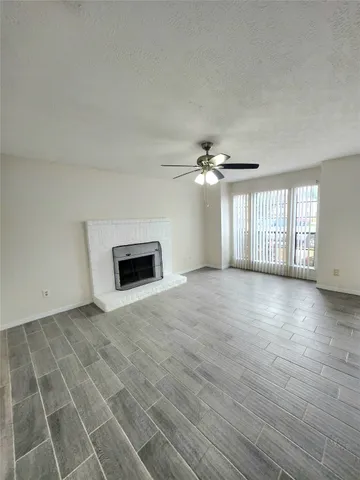 an empty room with windows and fireplace