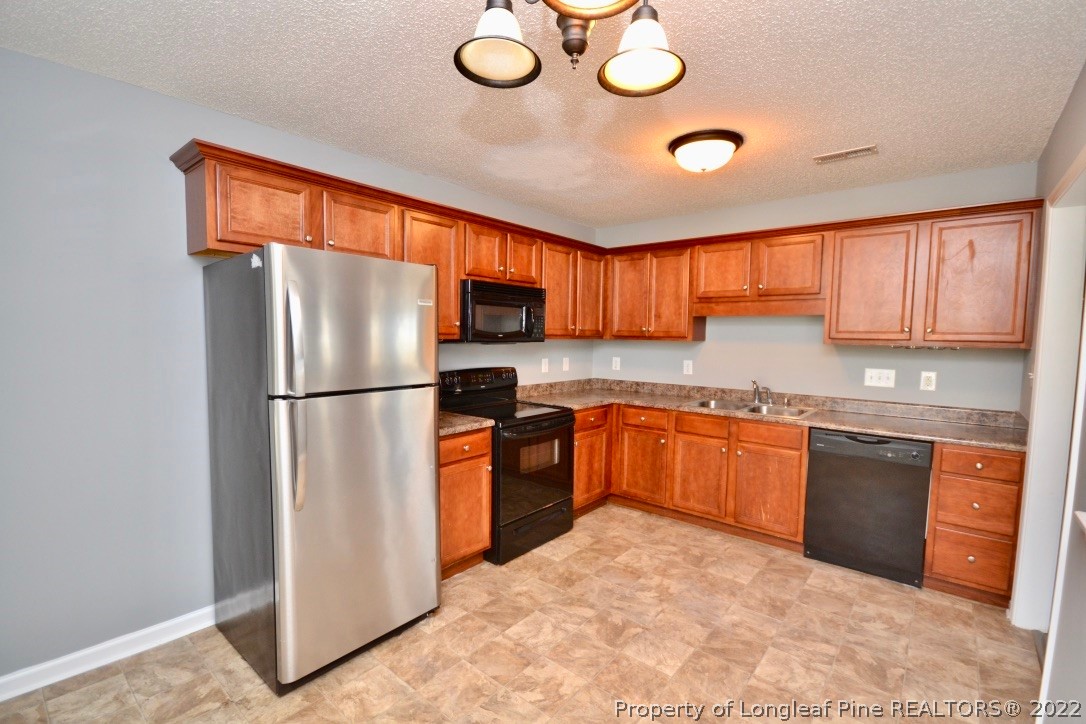 2330 Chasewater Road Fayetteville, NC 28306 - Photo 11 of 44 a kitchen with stainless steel appliances granite countertop a refrigerator sink stove and microwave
