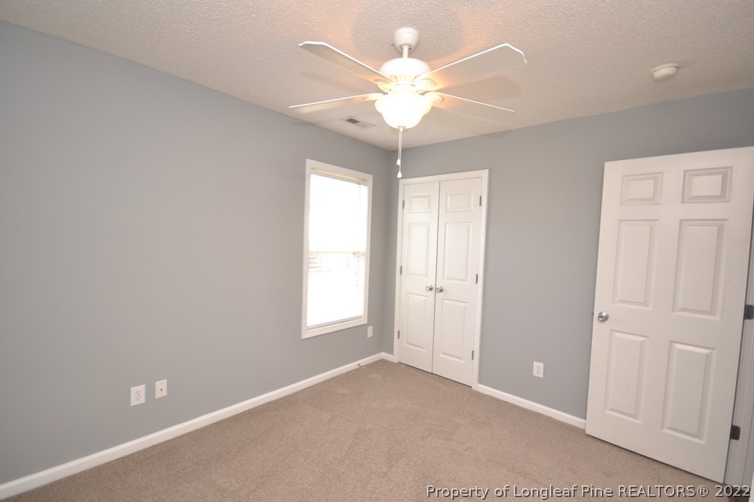 2330 Chasewater Road Fayetteville, NC 28306 - Photo 21 of 44 an empty room with windows and chandelier fan
