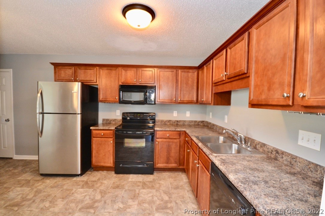 2330 Chasewater Road Fayetteville, NC 28306 - Photo 10 of 44 a kitchen with stainless steel appliances granite countertop a refrigerator a stove top oven a sink and dishwasher