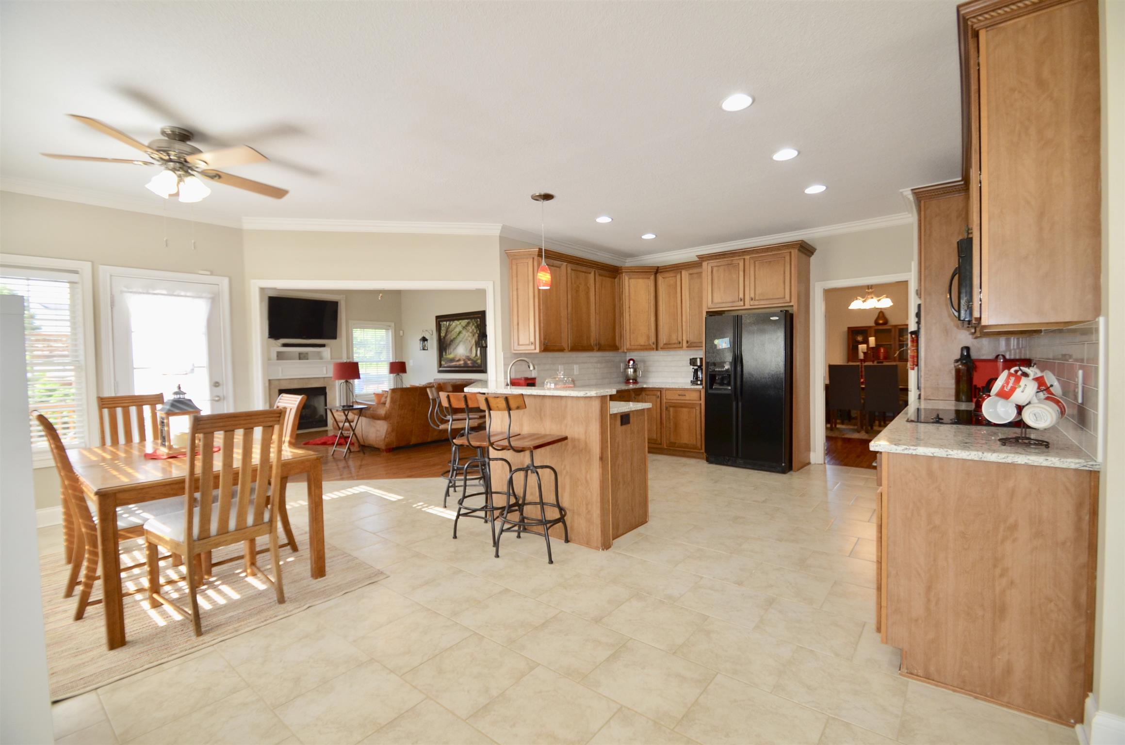 710 Dixie Bee Road Clarksville, TN 37043 - Photo 8 of 30 a kitchen with stainless steel appliances kitchen island granite countertop a refrigerator a stove a sink a dining table and chairs with wooden floor