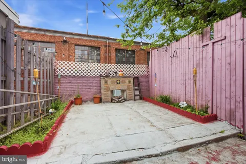 a view of a house with backyard and wooden fence
