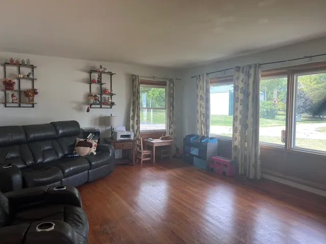 a living room with furniture and a wooden floor