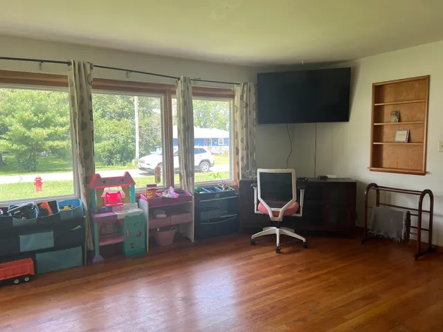 a view of a workspace with furniture and a window
