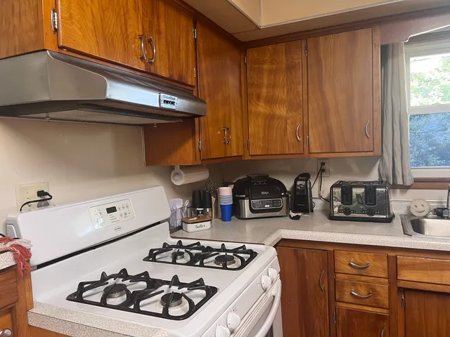 a kitchen with a stove a sink and cabinets