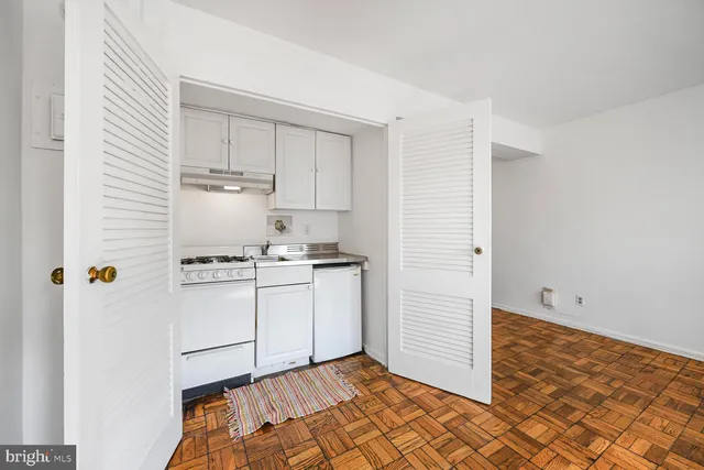 a kitchen with a refrigerator and white cabinets