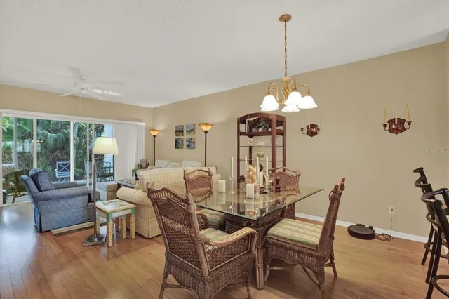 a dining room with furniture a chandelier and wooden floor