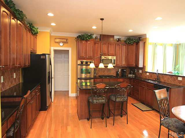 212 Quarryrock Road Holly Springs, NC 27540 - Photo 9 of 25 The kitchen overlooks the bright sunroom and provides easy access to the family room, dining room, and stairway. Kitchen