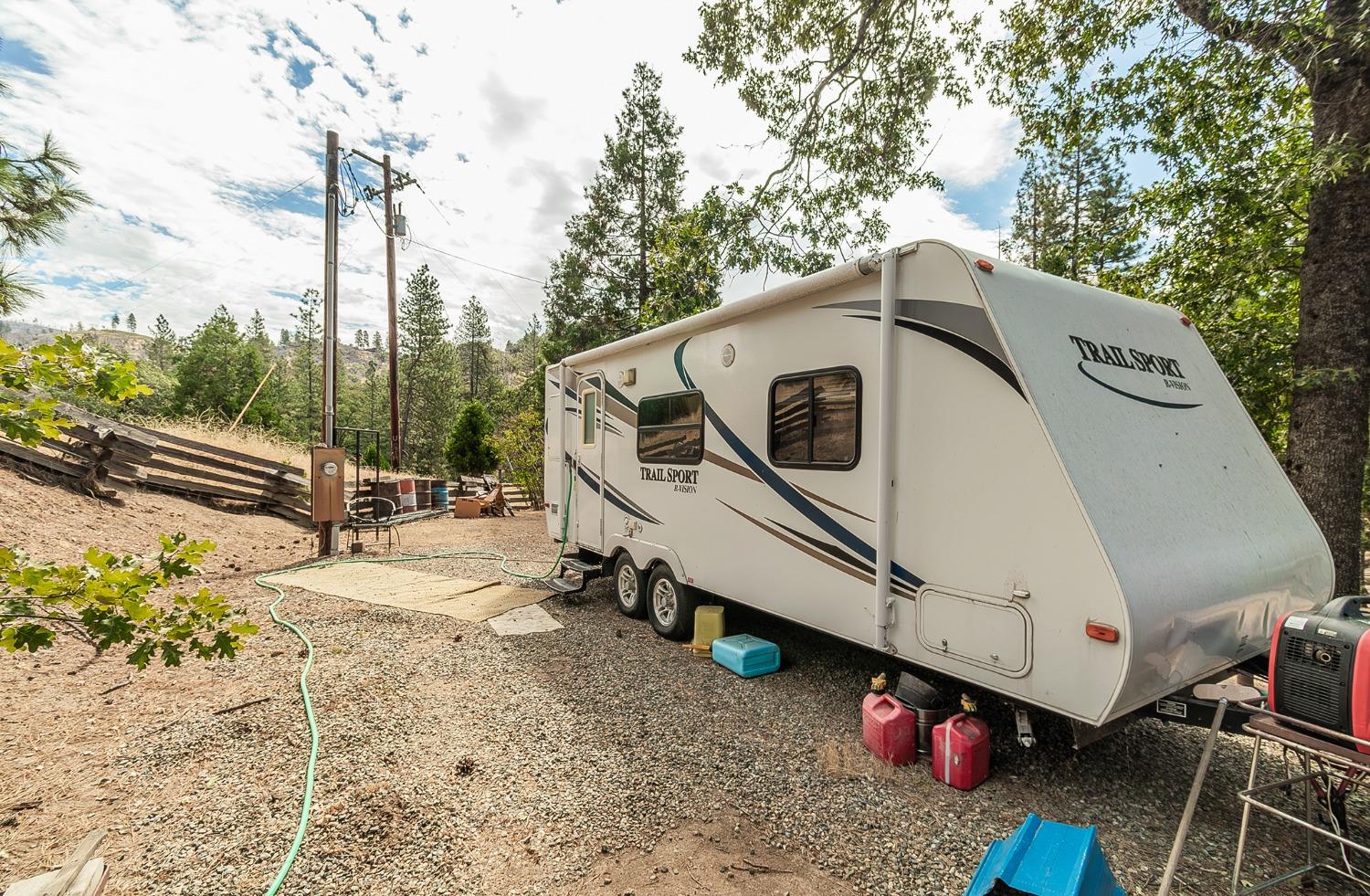 33288 Linson Road Tollhouse, CA 93667 - Photo 36 of 54 a white house with tall trees in front of it