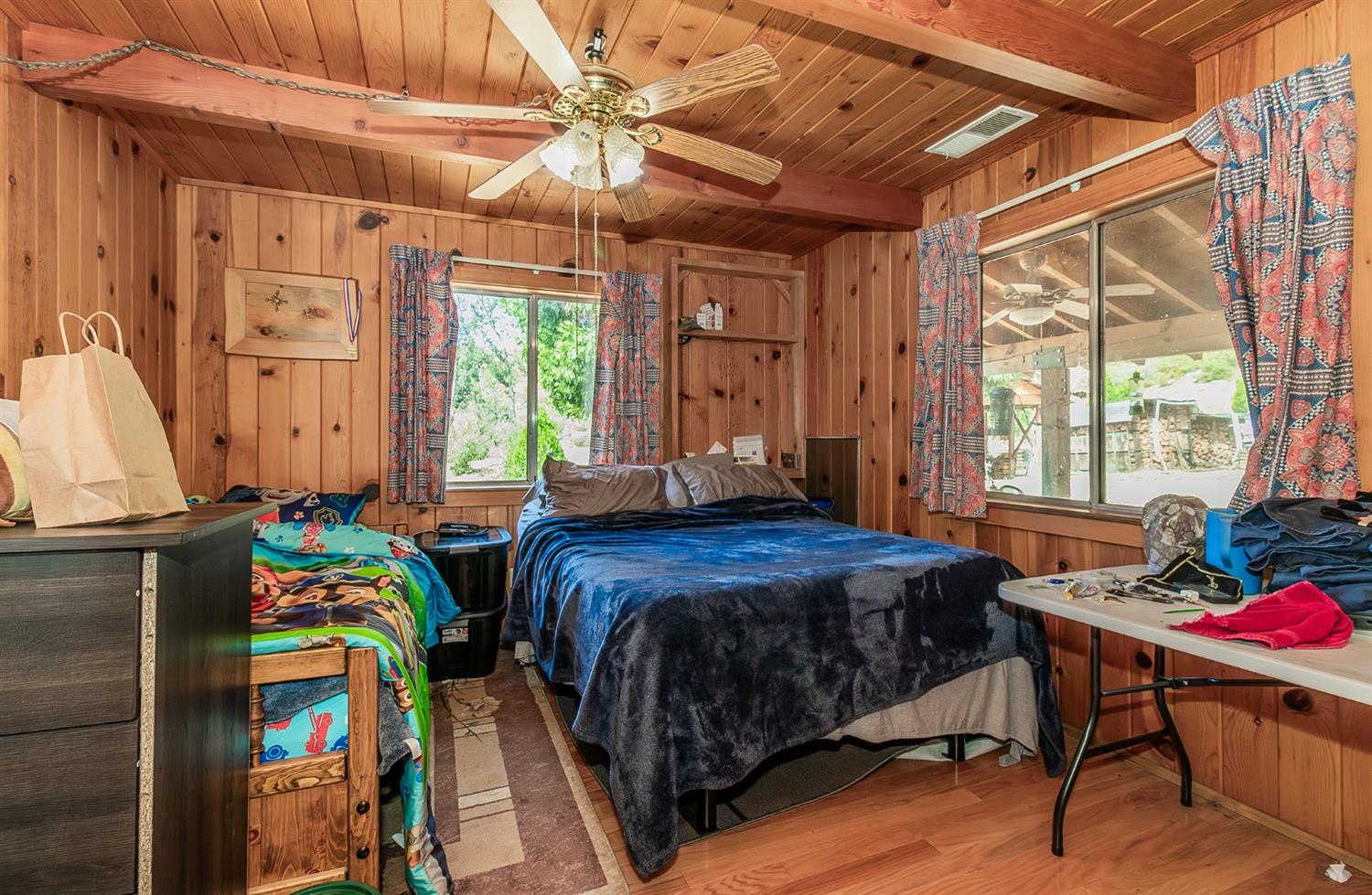 33288 Linson Road Tollhouse, CA 93667 - Photo 8 of 54 a bedroom with a bed a window and a chandelier