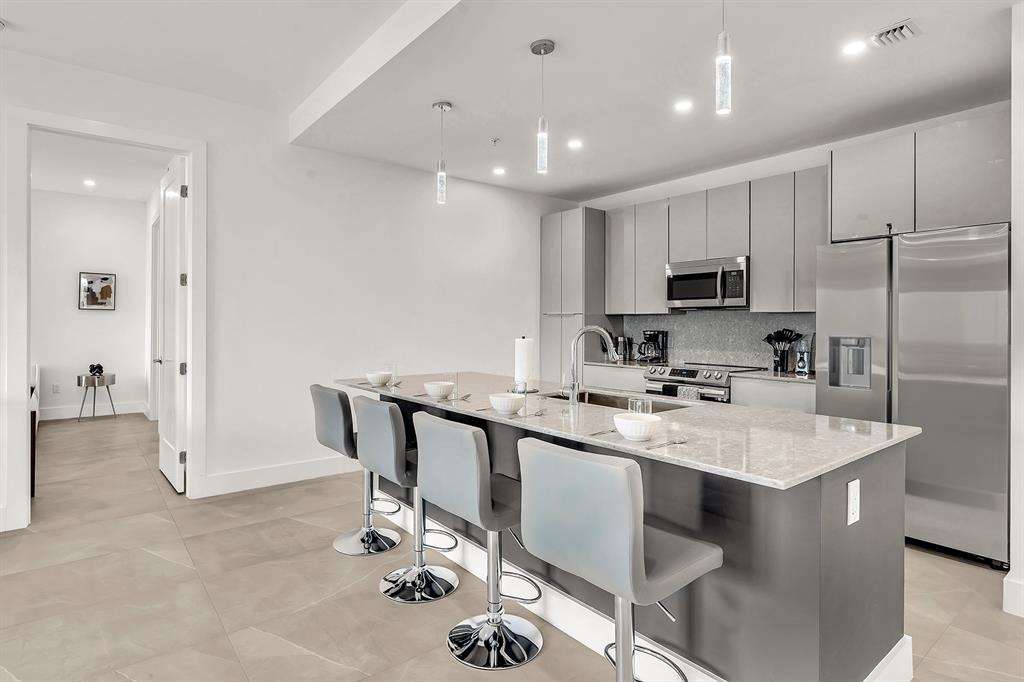 2100 Miami Road, Unit 403 Fort Lauderdale, FL 33316 - Photo 10 of 38 a kitchen with kitchen island a sink appliances and cabinets