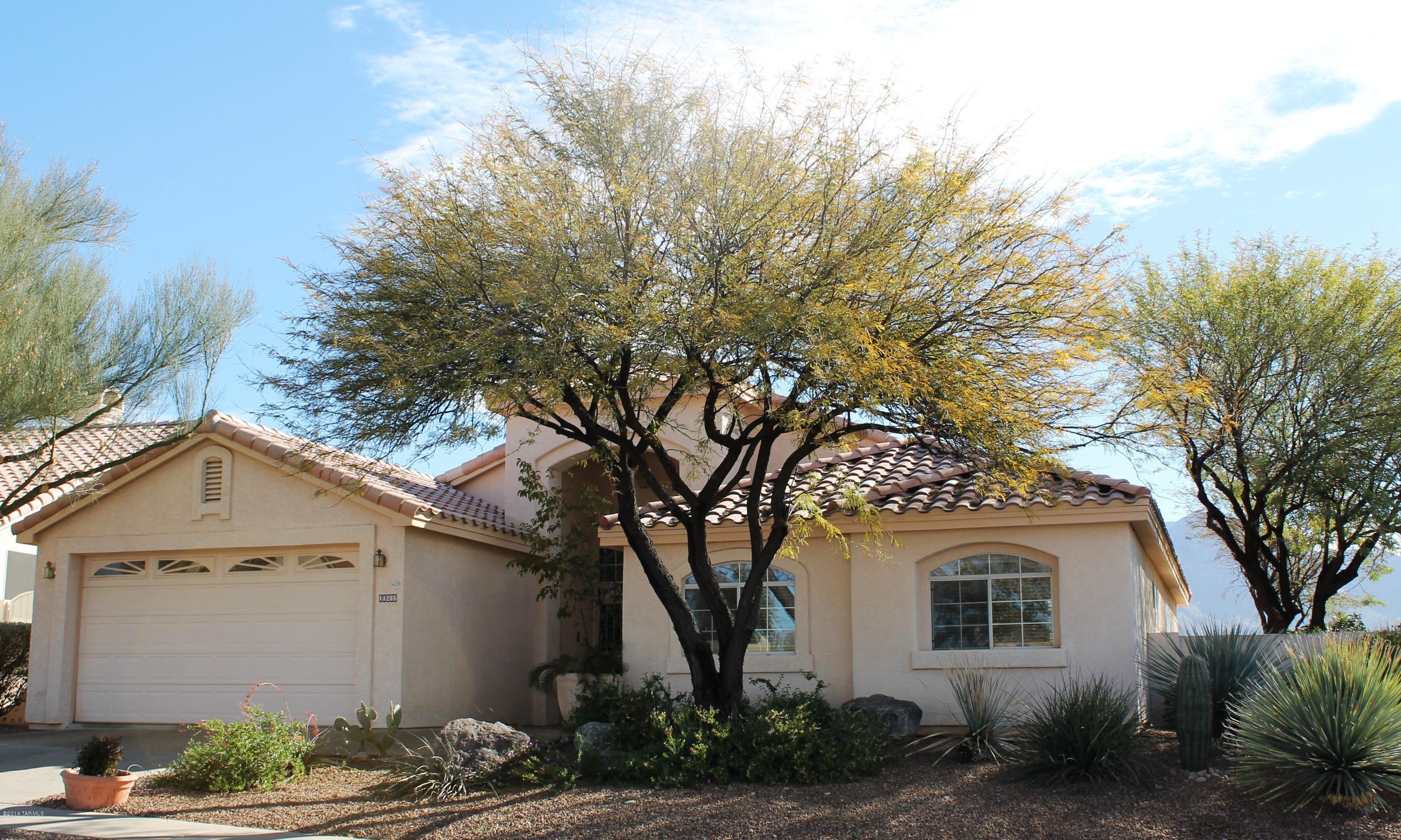 11286 North Copper Spring Trail Tucson, AZ 85737 - Photo 2 of 8 a front view of a house with a yard