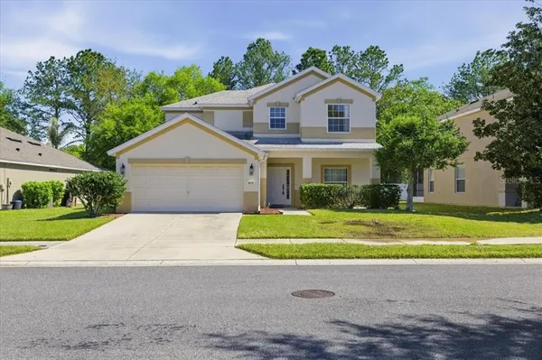 a front view of a house with a yard and garage