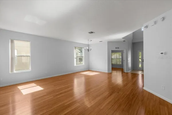 a view of empty room with window and wooden floor