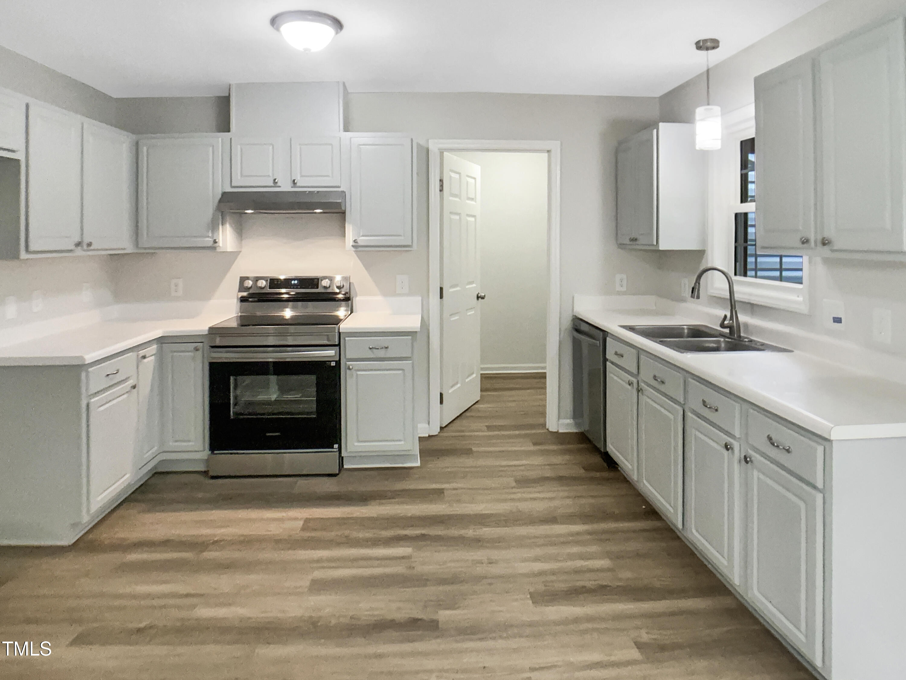 3509 Neptune Drive Raleigh, NC 27604 - Photo 11 of 18 a kitchen with stainless steel appliances granite countertop a stove sink and cabinets