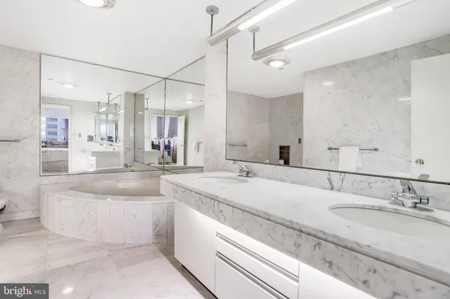a bathroom with a granite countertop sink mirror and bathtub