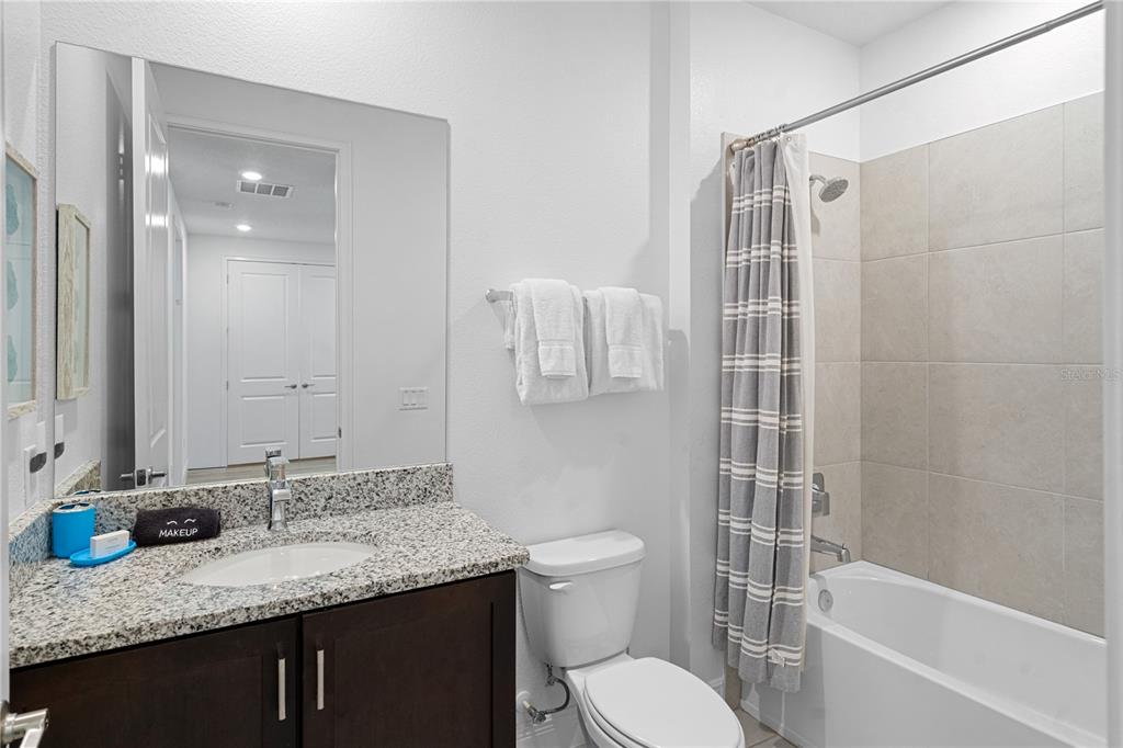 7622 Excitement Drive Reunion, FL 34747 - Photo 33 of 46 a bathroom with a granite countertop sink toilet and shower